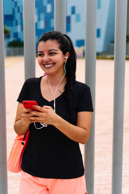 Mujer sonriente enviando un mensaje en su teléfono celular