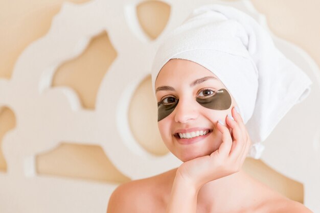 Mujer sonriente envuelta en una toalla después del baño