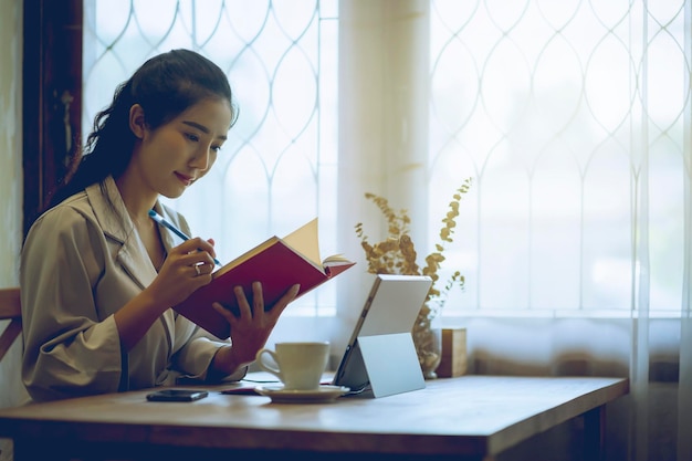 Mujer sonriente escribiendo en un libro en casa