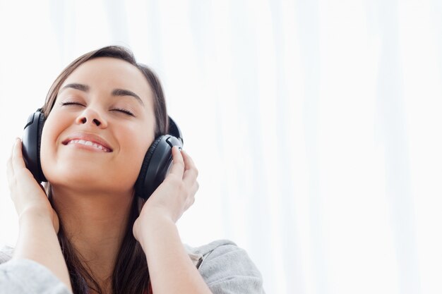 Una mujer sonriente escuchando sus auriculares