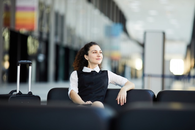 Mujer sonriente esperando en el aeropuerto