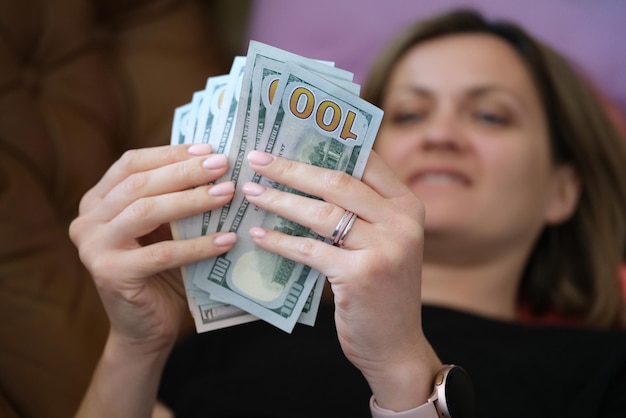 Mujer sonriente feliz contando dinero en casa