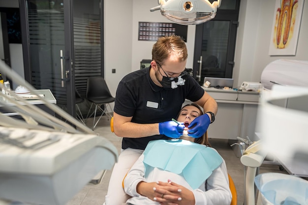 Mujer sonriente feliz es examinada por un dentista en una clínica dental Dientes sanos y medicina concepto de odontología