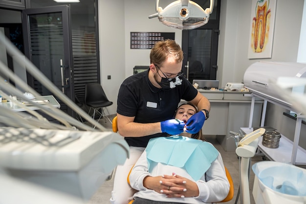 Foto una mujer sonriente feliz es examinada por un dentista en una clínica dental