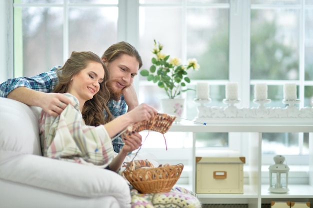 Mujer sonriente feliz con hombre tejiendo