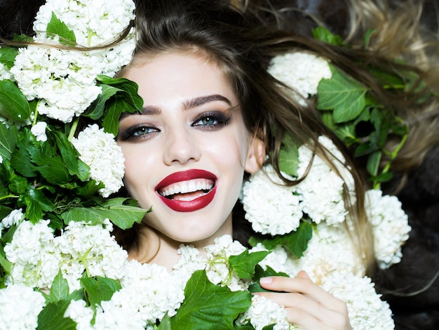 Mujer sonriente en flor blanca