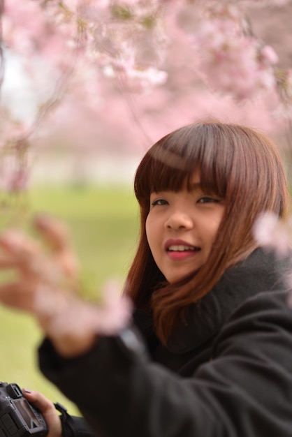 Foto mujer sonriente con franja en un parque público