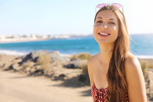 Mujer sonriente con gafas de sol en la playa