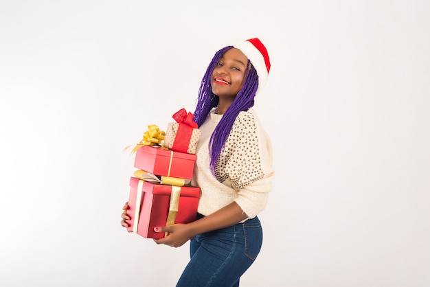 Mujer sonriente con gorro de Papá Noel con regalo de Navidad