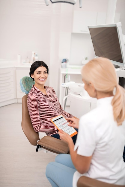 Mujer sonriente hablando con su dentista sobre la próxima cita