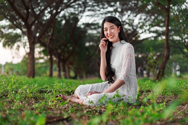 mujer sonriente hablando por teléfono móvil en el parque