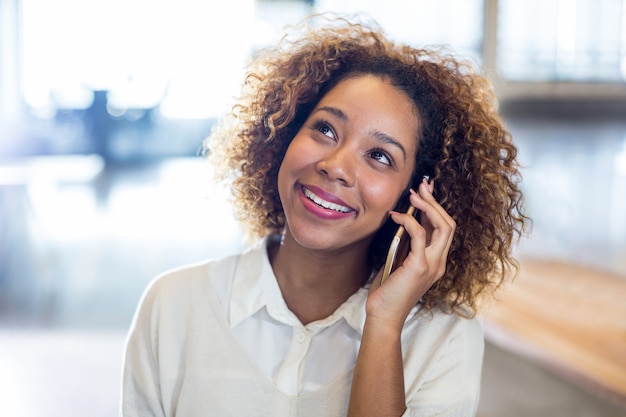 Mujer sonriente hablando por teléfono