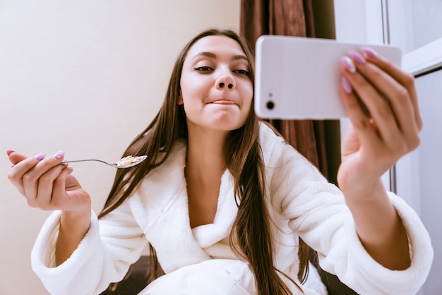 Mujer sonriente haciendo selfie a la hora del desayuno