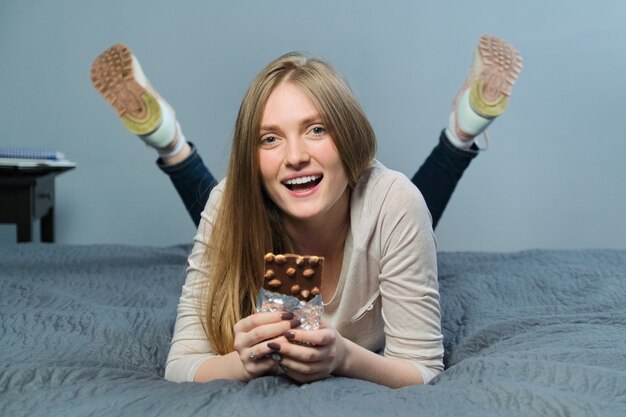 Mujer sonriente hermosa joven con chocolate.