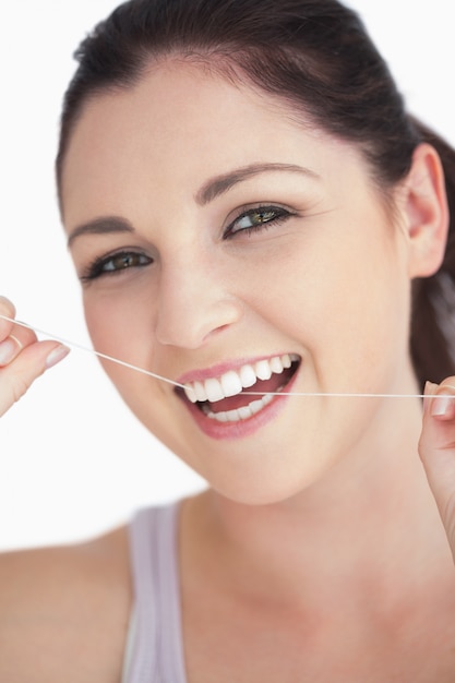 Mujer sonriente con hilo dental