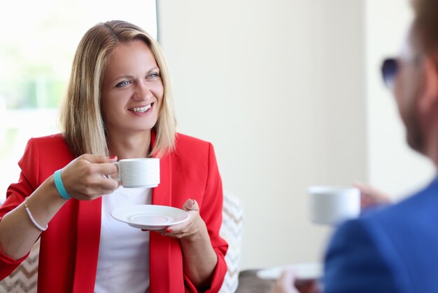 Mujer sonriente y hombre bebiendo café closeup