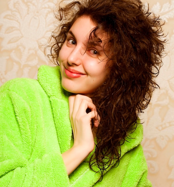 Mujer sonriente joven en bata de baño