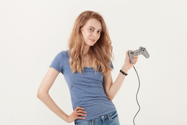 Mujer sonriente joven con gamepad aislado sobre fondo blanco.