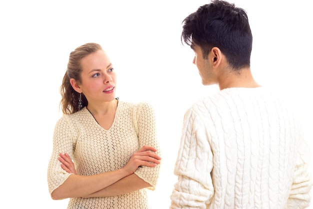 Mujer sonriente joven con hombre guapo joven con cabello oscuro en suéteres blancos hablando