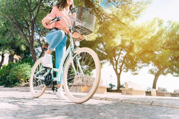 Foto mujer sonriente joven monta su bicicleta por las calles de un casco antiguo