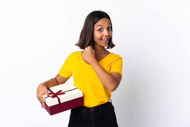 Mujer sonriente joven sosteniendo un regalo