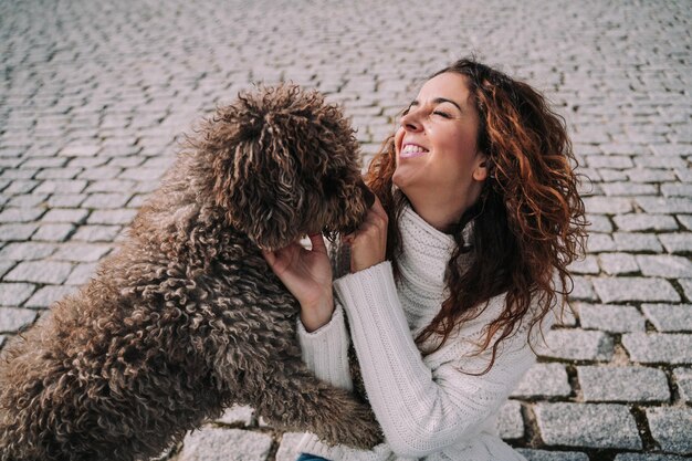 Mujer sonriente jugando con el perro