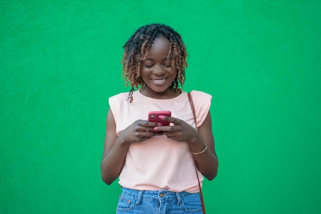 Una mujer sonriente lee un mensaje en su teléfono Emociones positivas Tecnologías