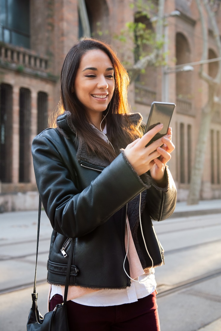 Foto mujer sonriente leyendo un mensaje en su teléfono
