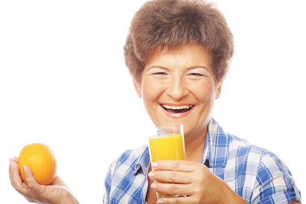 Foto mujer sonriente madura con jugo de naranja