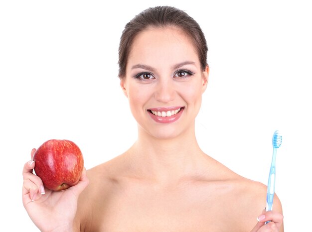 Mujer sonriente con manzana y cepillo de dientes aislado en blanco