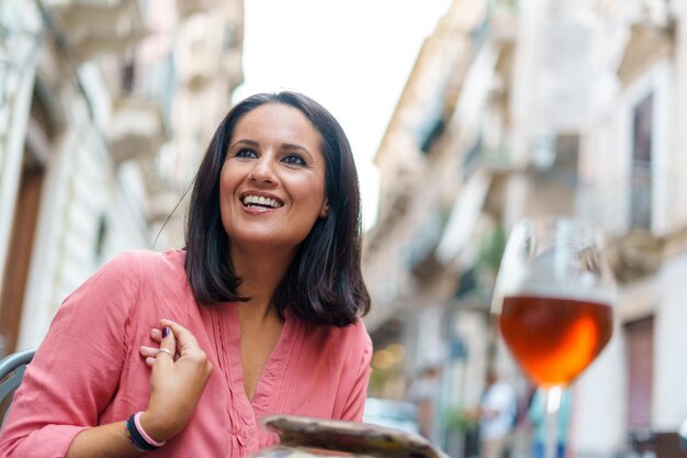 Foto mujer sonriente mirando lejos en la ciudad