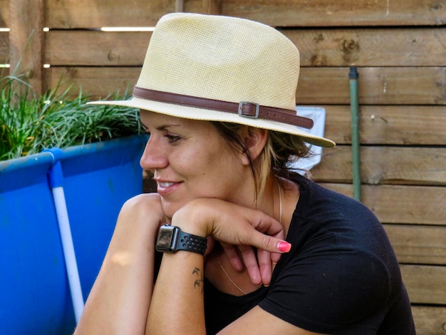 Foto mujer sonriente mirando hacia otro lado mientras lleva sombrero