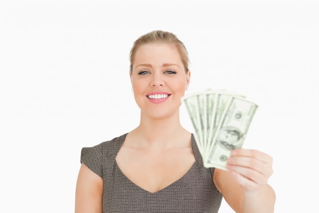 Mujer sonriente mostrando billetes de dólares