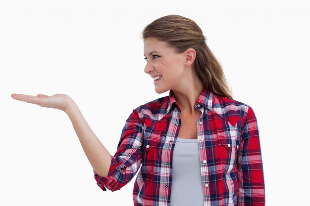 Mujer sonriente mostrando un espacio de copia