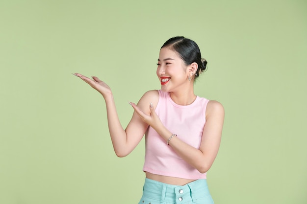 Mujer sonriente mostrando la palma de la mano abierta con espacio de copia para producto o texto