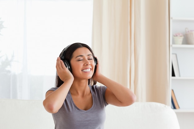 mujer sonriente con los ojos cerrados y auriculares