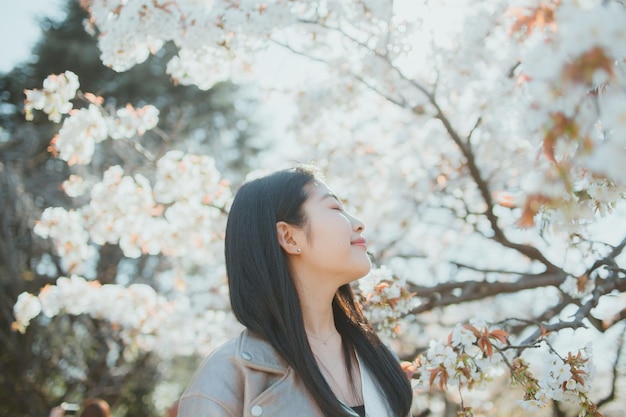 Mujer sonriente con los ojos cerrados de pie al aire libre
