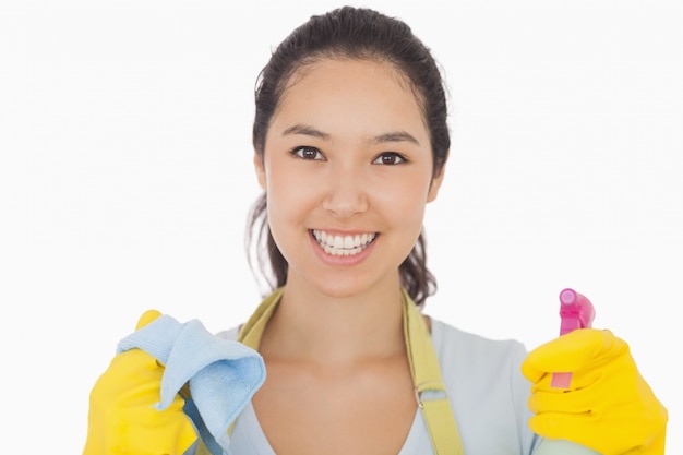 Mujer sonriente con paño y botella de spray