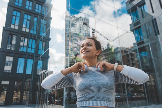 Foto mujer sonriente con el pelo oscuro cerca de los edificios