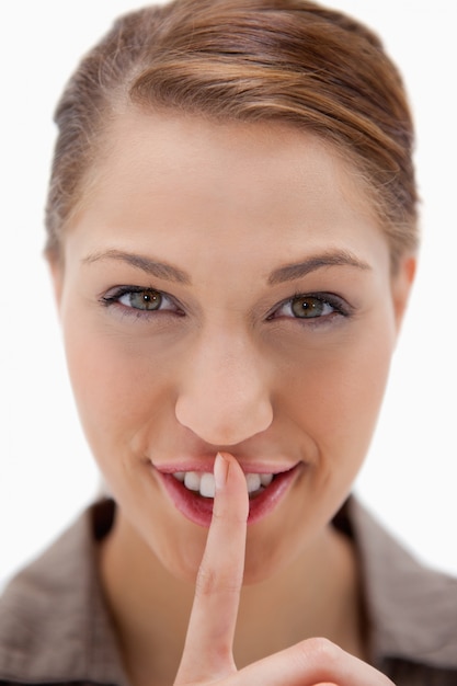 Foto mujer sonriente pidiendo silencio