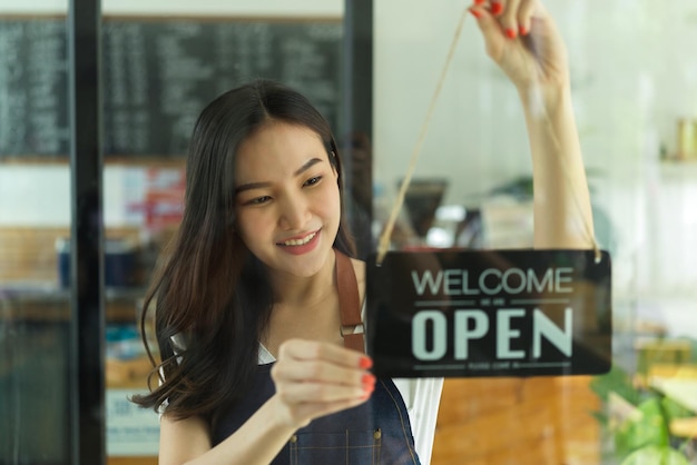 Foto mujer sonriente de pie junto al vidrio en la tienda