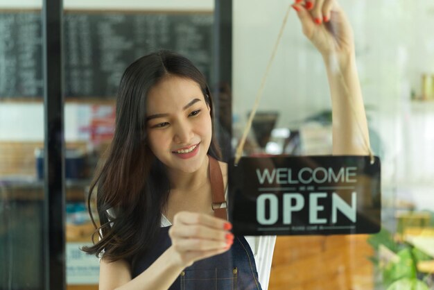 Mujer sonriente de pie junto al vidrio en la tienda