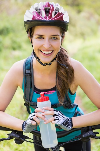 Mujer sonriente de pie junto a su bicicleta