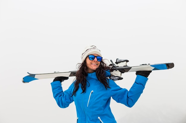 Foto una mujer sonriente de pie con una tabla de snowboard de pie contra la niebla del invierno