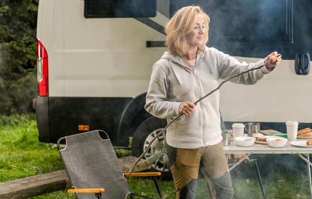 Mujer sonriente preparando una comida de barbacoa al aire libre