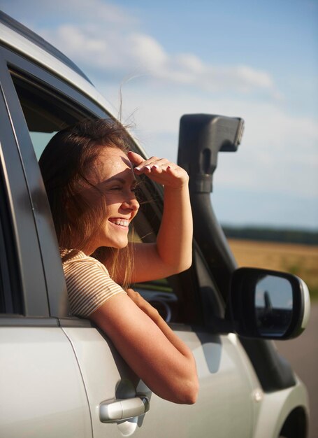 Foto mujer sonriente protegiendo los ojos en el coche