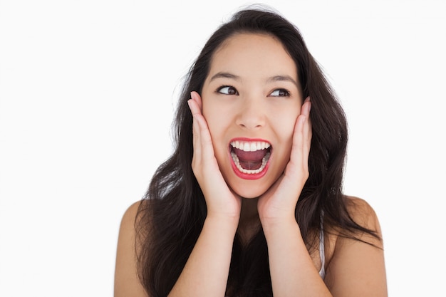 Mujer sonriente que grita en el fondo blanco