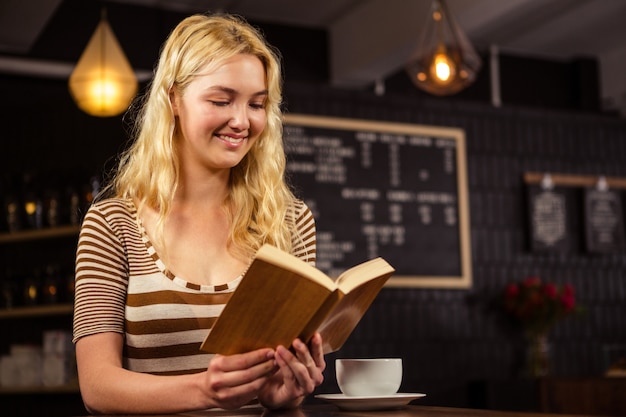 Mujer sonriente que lee un libro