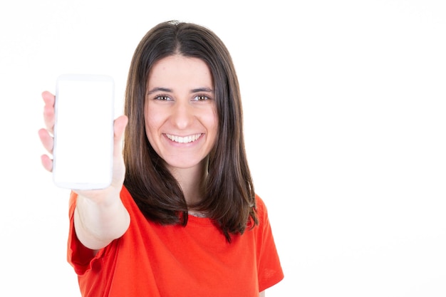 Mujer sonriente que presenta mostrando teléfono móvil con pantalla vacía