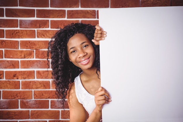 Mujer sonriente que sostiene la pizarra